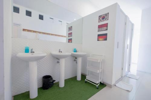 a bathroom with two sinks and a walk in shower at Capsule Inn Bali in Legian