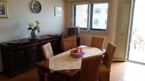 a dining room with a table with a bowl of fruit on it at Villa Carmelas in Taormina