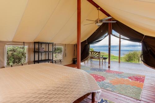 a bedroom with a bed with a view of the ocean at Waipi'o Lodge in Kukuihaele