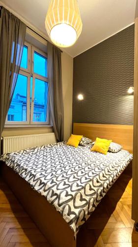 a large bed in a room with a large window at Homely Studio in Krakow