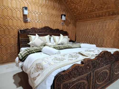 a bedroom with a large bed with a wooden wall at Hotel Mughal India in Sonāmarg