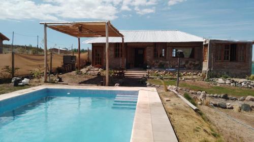 a house with a swimming pool in front of it at El Rincon in Cacheuta