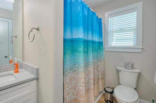 a bathroom with a toilet and a shower curtain at ShortWalk2 in Oak Island