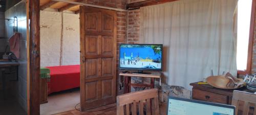 a living room with a television and a bedroom at El Rincon in Cacheuta