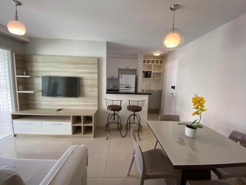 cocina y sala de estar con mesa y TV en TEMPORADA737 Top 3 Quartos na Atalaia Condominio Clube com Piscina, en Aracaju