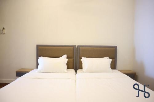 two beds with white sheets and white pillows at Homesuite' Home at The Loft in Kota Kinabalu