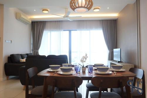 a living room with a table with chairs and a couch at Homesuite' Home at The Loft in Kota Kinabalu