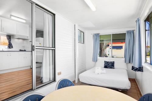 a small room with a bed and a table and chairs at Pyramid Holiday Park in Tweed Heads