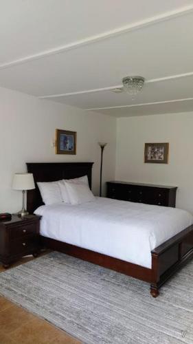 a bedroom with a large bed with white sheets and a lamp at White Fang Motel in Wawa