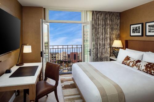 a hotel room with a bed and a desk and a window at The Benson Hotel & Faculty Club in Aurora