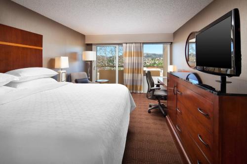 a hotel room with a bed and a flat screen tv at Sheraton Agoura Hills Hotel in Agoura Hills