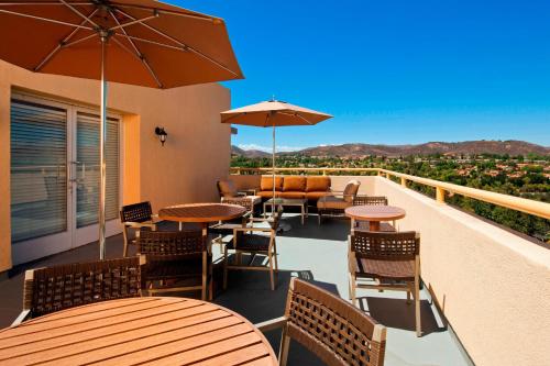 a balcony with tables and chairs and an umbrella at Sheraton Agoura Hills Hotel in Agoura Hills