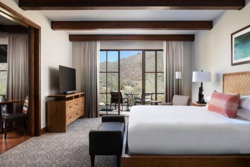 a hotel room with a bed and a television at The Ritz-Carlton, Dove Mountain in Marana