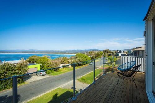 a deck with a bench and a view of the water at Sea Change and Studio on Tasman in Merimbula
