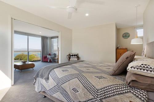 a bedroom with a large bed with a view of the ocean at Sea Change and Studio on Tasman in Merimbula