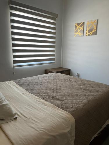 a bedroom with a large bed with a window at El Departamento Playa Sur in Mazatlán