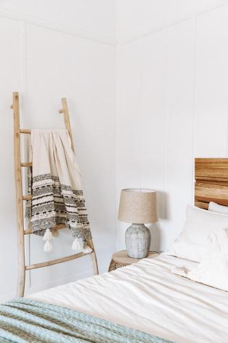a bedroom with a bed and a chair at 1900's cosy cottage - Peaceful couples retreat in the heart of McLaren Vale in McLaren Vale