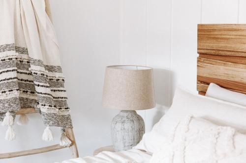 a bedroom with a lamp next to a bed at 1900's cosy cottage - Peaceful couples retreat in the heart of McLaren Vale in McLaren Vale