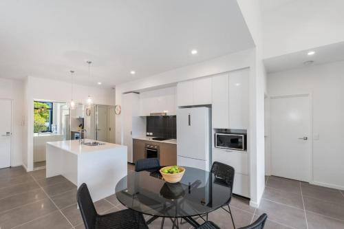 a kitchen with a table and chairs and a counter at H6B - Round About Bulimba in Brisbane