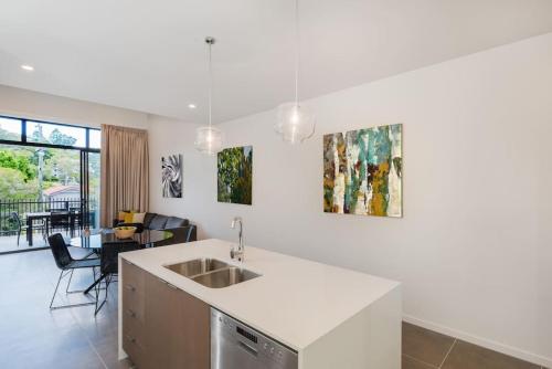 a kitchen with a sink and a living room at H6B - Round About Bulimba in Brisbane