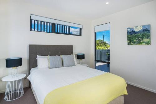a bedroom with a large bed and a balcony at H6B - Round About Bulimba in Brisbane