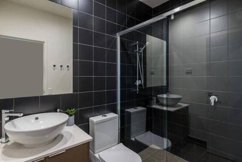a bathroom with a sink and a toilet and a shower at H6B - Round About Bulimba in Brisbane