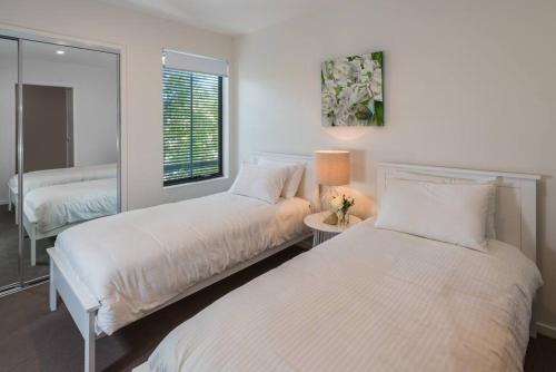 a bedroom with two beds and a window at H6B - Round About Bulimba in Brisbane