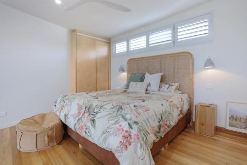 a bedroom with a large bed with a wooden headboard at Sea Change and Studio on Tasman in Merimbula