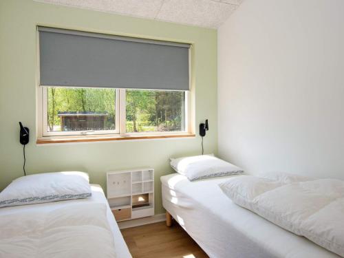 two twin beds in a room with a window at Luxury Retreat with Pool - By Traum Ferienwohnungen in Oksbøl