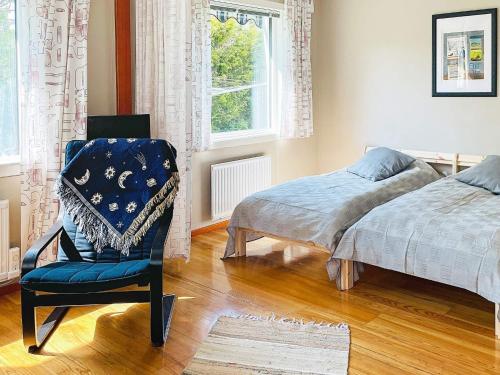 ein Schlafzimmer mit einem Bett, einem Stuhl und einem Fenster in der Unterkunft Holiday home ELLÖS VII in Ellös