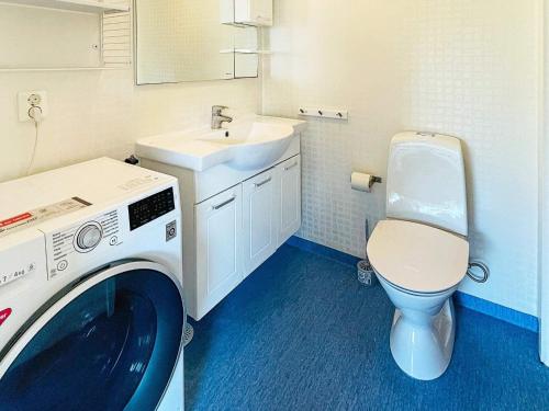 ein Badezimmer mit einer Waschmaschine und einem Waschbecken in der Unterkunft Holiday home ELLÖS VII in Ellös