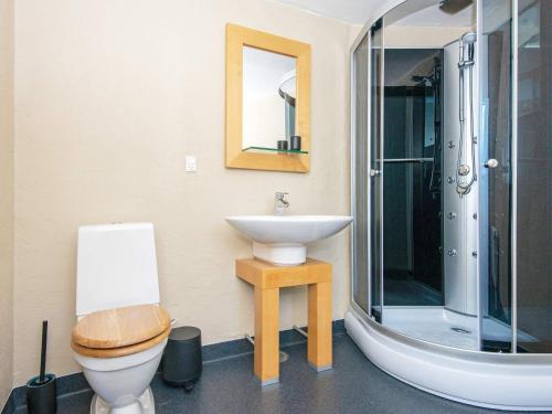 een badkamer met een wastafel, een toilet en een spiegel bij Holiday home Grenaa XLVIII in Grenå