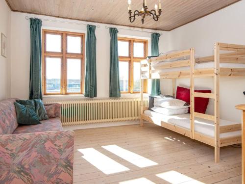 een slaapkamer met een stapelbed en een bank bij Holiday home Grenaa XLVIII in Grenå