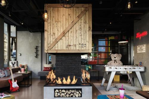 a room with a fireplace with a teddy bear sitting on a table at Moxy Belgrade in Belgrade