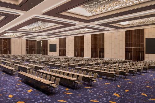 an empty lecture hall with rows of tables and chairs at The Westin Surabaya in Surabaya