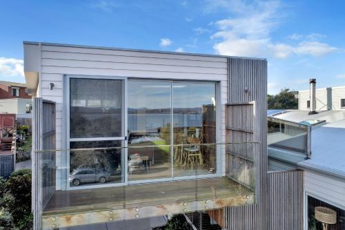 a house with a large window on a roof at Sea Change and Studio on Tasman in Merimbula