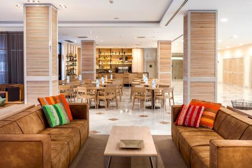 a hotel lobby with couches and tables and a restaurant at Barceló Cabo de Gata in Retamar