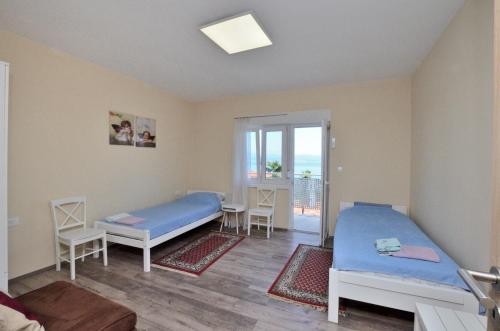 a room with two beds and a balcony at Apartments Bela in Lovran