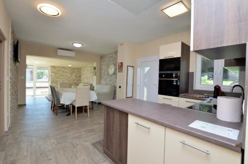 a kitchen with a counter and a dining room with a table at Apartments Bela in Lovran