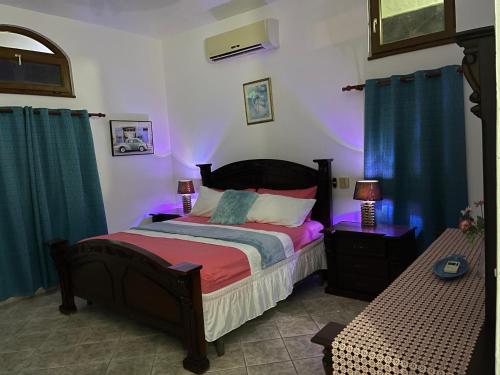 a bedroom with a bed with purple lights at Ocean Breeze Villa Carismar in Cabrera