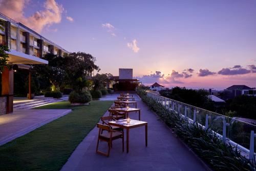 une rangée de tables sur le côté d'un bâtiment dans l'établissement Four Points by Sheraton Bali, Ungasan, à Jimbaran