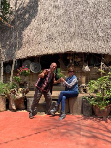 a man and a woman sitting on a bench at Khu Du Lịch Sinh Thái, Nghỉ dưỡng Homestay Hoàng Ánh - Kon Xom Luh in Kon Tum