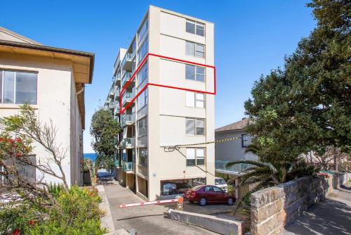 a white apartment building with a red stripe on it at S16S - Bondi Vistas in Sydney