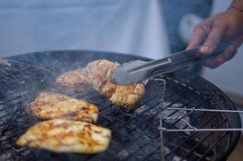 a person is cooking meat on a grill at Villa Kayu Raja in Seminyak
