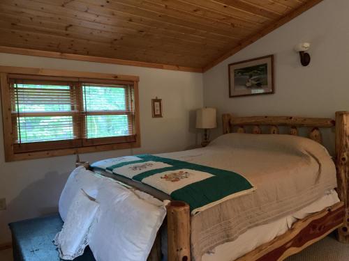 ein Schlafzimmer mit einem Bett in einer Hütte mit einem Fenster in der Unterkunft Antler Ridge in Terra Alta