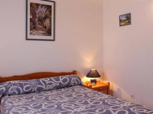 une chambre avec un lit et une lampe sur une table dans l'établissement Villa spacieuse 3 pièces avec mezzanine, 6 couchages, proche plage, commerces et balnéothérapie - FR-1-229-855, à Gruissan