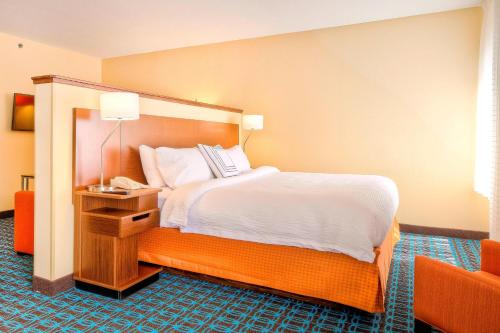a hotel room with a bed and a chair at Fairfield Inn and Suites by Marriott Durham Southpoint in Durham