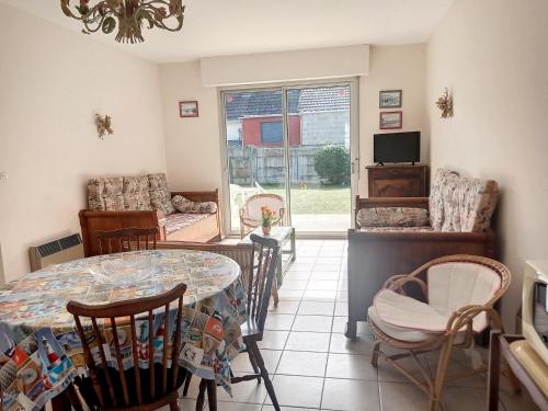 un salon avec une table et des chaises dans l'établissement Appartement RDC avec jardin à 500m de la plage et 800m des commerces - FR-1-361-493, à Jullouville