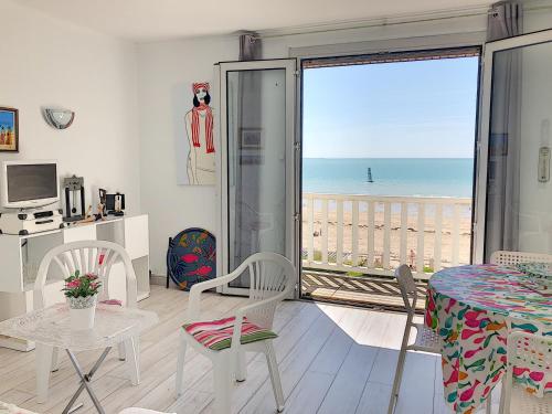 un salon avec vue sur l'océan dans l'établissement Appartement avec balcon, jardin, et accès plage - FR-1-361-492, à Jullouville