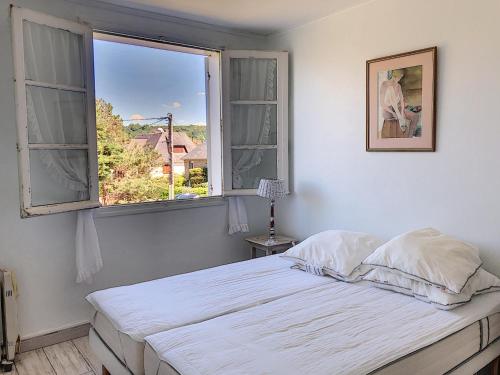 a bedroom with a bed and an open window at Appartement avec balcon, jardin, et accès plage - FR-1-361-492 in Jullouville-les-Pins